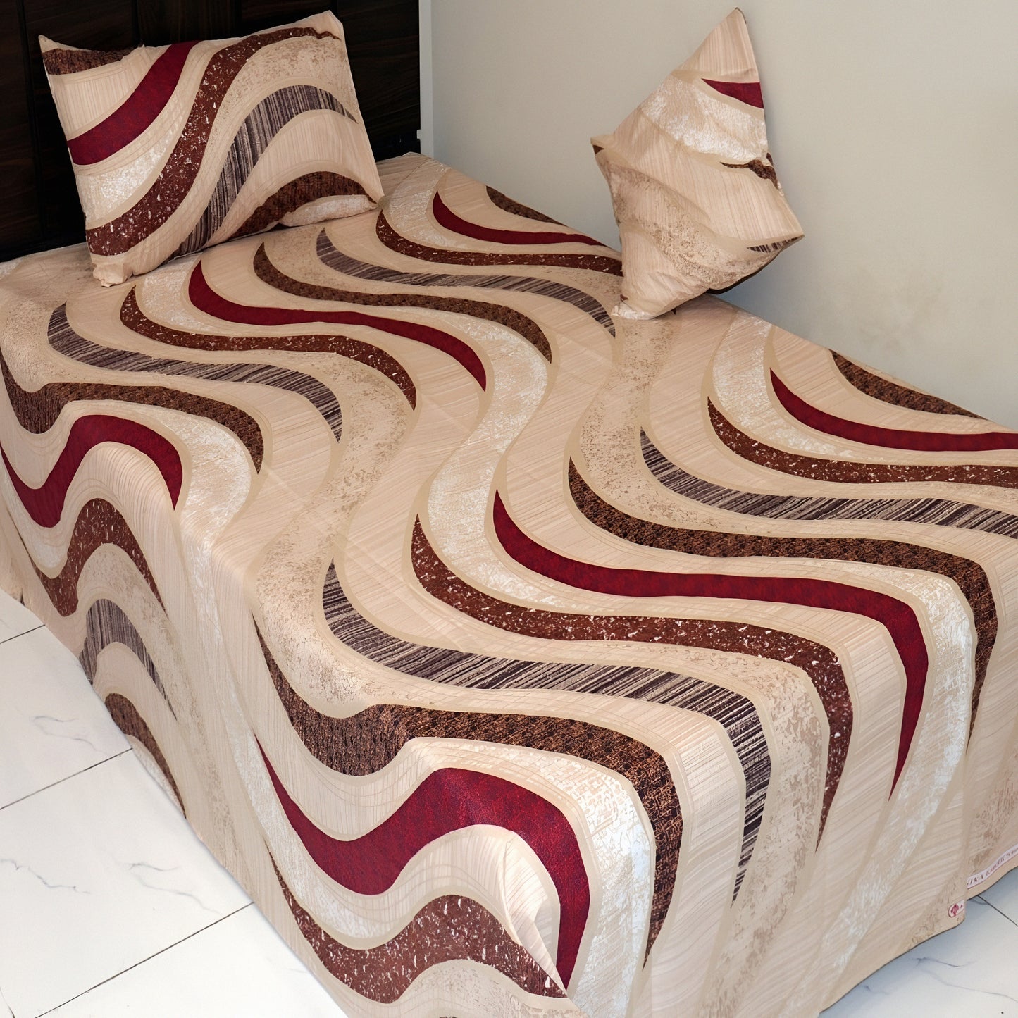 Beige and brown patterned bedspread with matching pillows on a bed.