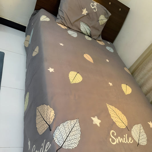 Grey single bedsheet with yellow & white leaf print and “Smile” lettering