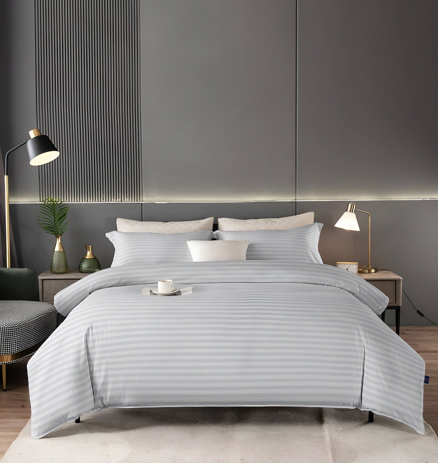 Silver striped bedding set on a bed in a modern bedroom with gray walls and decor.