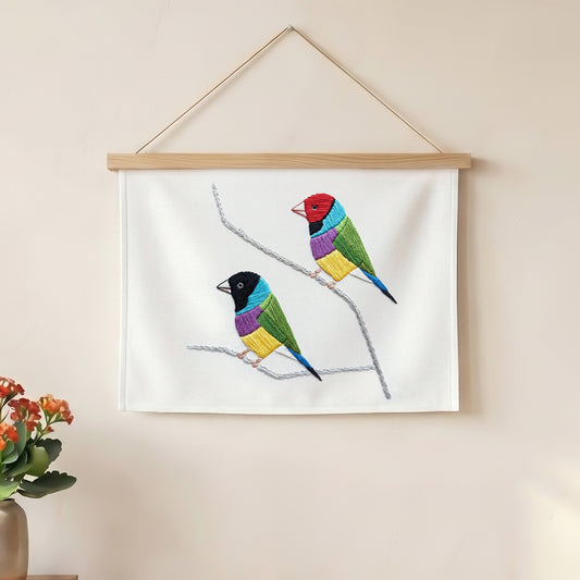 Nature-inspired textile wall hanging featuring two vibrant embroidered birds.