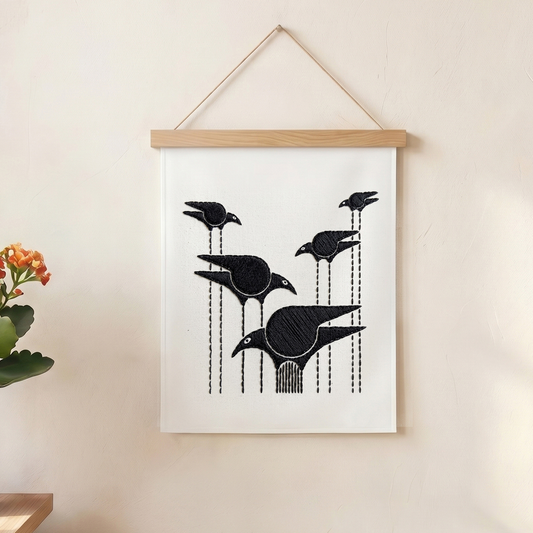 Handmade textile wall hanging featuring abstract flying birds in black embroidery.