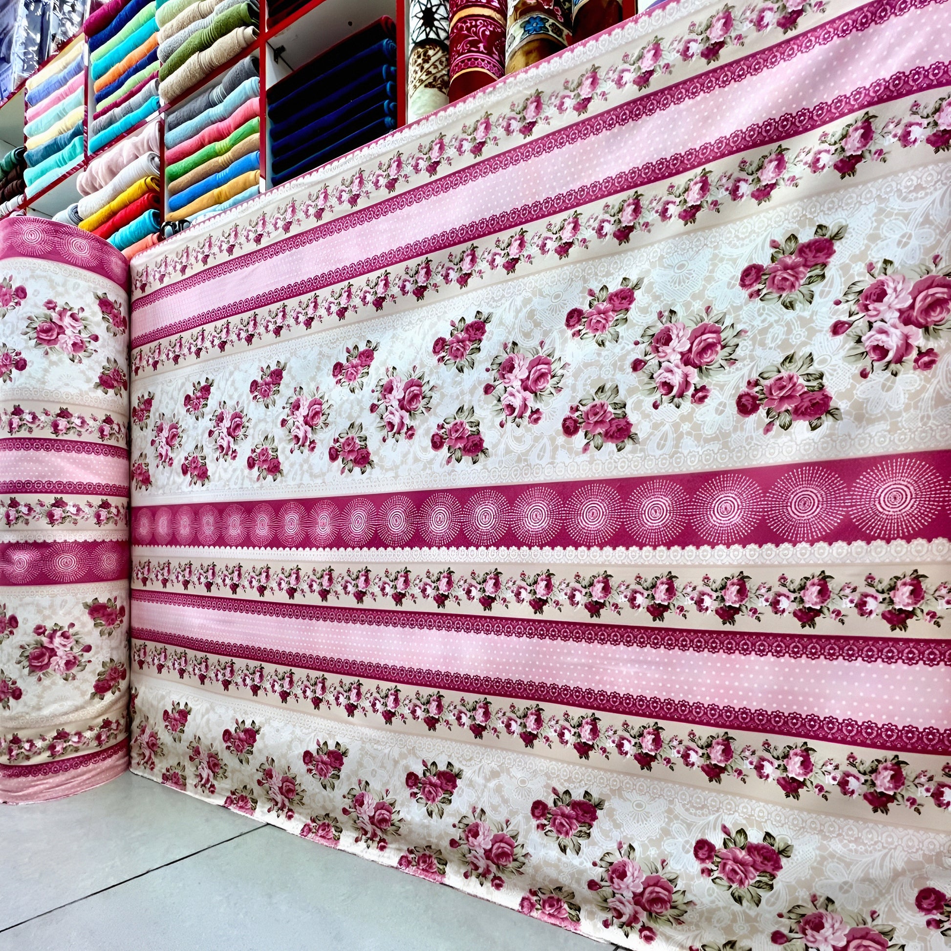 Pink floral bedsheet fabric roll wholesale display in UAE textile shop